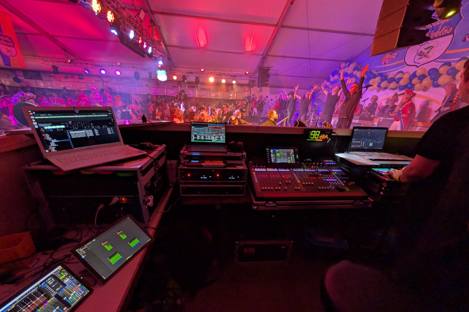 FOH-Platz mit Digitalmischpult, Zuspieler-Laptops und Pegelanzeige, Band auf der Bühne im Festzelt